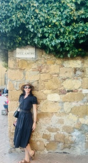 Sandra Hodes standing beside a stone wall
